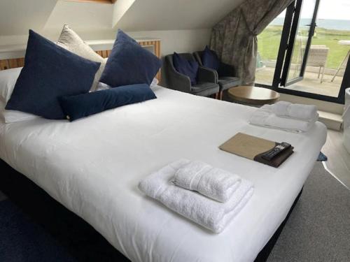 a large white bed with towels on top of it at The Dormy House Hotel in Cromer