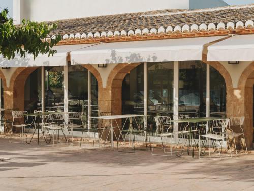 a group of tables and chairs in front of a building at wecamp Jávea in Jávea