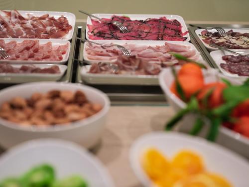 a buffet filled with different types of meats and vegetables at WANDERLUST HOTEL - SUITE & SPA - APARTMENTS & VILLAS - Bardolino, Lago di Garda - Verona in Bardolino