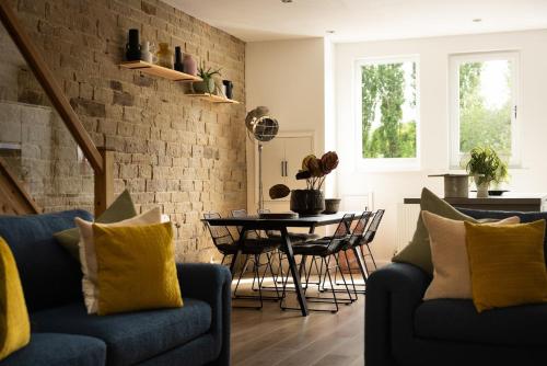a living room with two blue couches and a table at The Wagon Shed in Sowerby Bridge