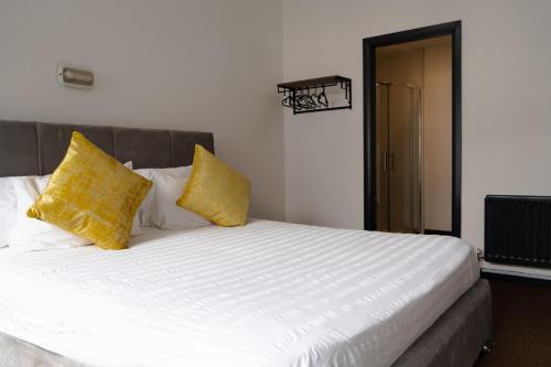 a bedroom with a bed with yellow pillows at Bushmills Hostel in Bushmills
