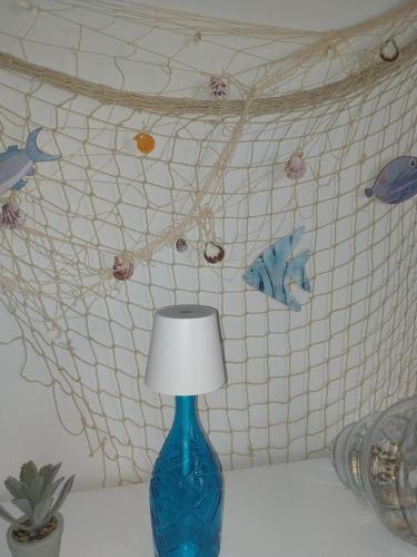 a blue vase sitting on a table with a lamp at Villa Ornella in Luni