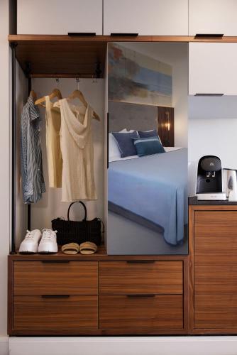 a bedroom with a bed and some clothes and shoes at Caesar Premier Eilat Hotel in Eilat