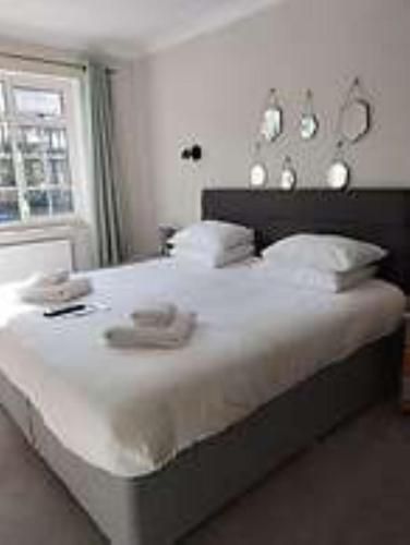a bedroom with a large white bed with a window at The Dormy House Hotel in Cromer