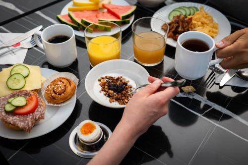 a table with plates of breakfast foods and drinks at Good Morning Mölndal in Mölndal