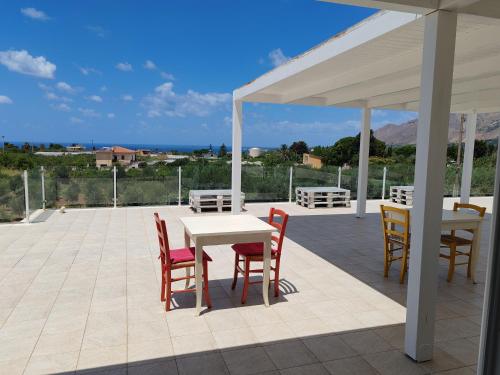 a patio with a table and chairs and a white canopy at Cà del Re Holiday in Partinico