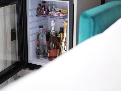 a refrigerator filled with lots of bottles of wine at WANDERLUST HOTEL - SUITE & SPA - APARTMENTS & VILLAS - Bardolino, Lago di Garda - Verona in Bardolino
