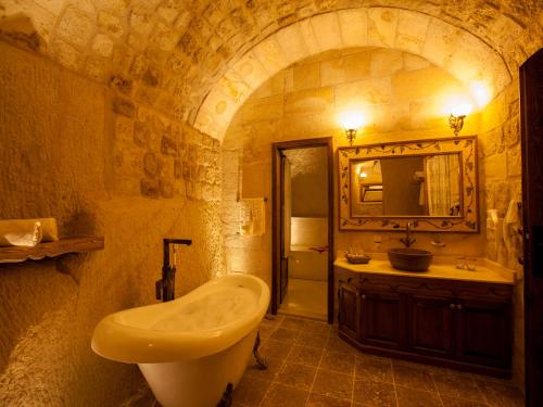 a bathroom with a sink and a toilet and a mirror at Kayakapi Premium Caves Cappadocia in Urgup