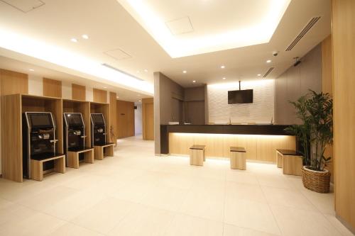 a large lobby with a cashierasteryasteryasteryasteryasteryasteryasteryasteryastery at Natural Hot Spring Shoun no Yu Dormy Inn Kofu Marunouchi in Kofu