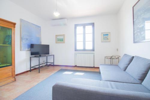 a living room with a couch and a tv at swimming pool and private garden, Casa in collina in Barcuzzi