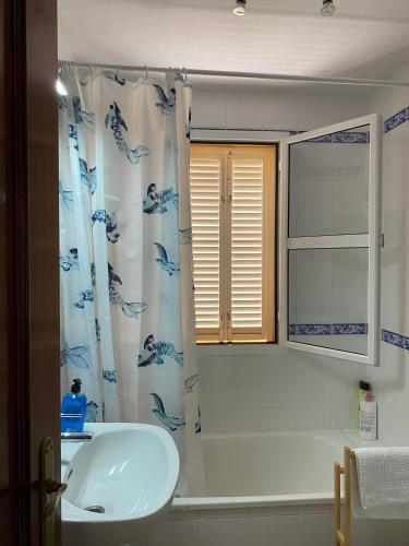 a bathroom with a sink and a shower curtain at BRISA del MAR in Isla Cristina