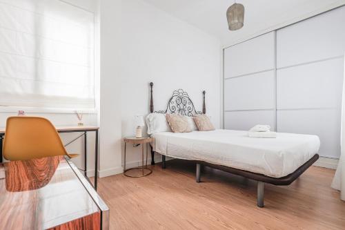 セビリアにあるLanza Tranquilo y acogedorの白いシーツと窓のあるベッドのある寝室