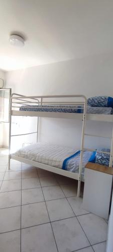 two bunk beds in a room with a tiled floor at Julie house in Sabaudia