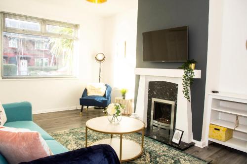a living room with a couch and a fireplace at Comfortable 3 bed house in Manchester