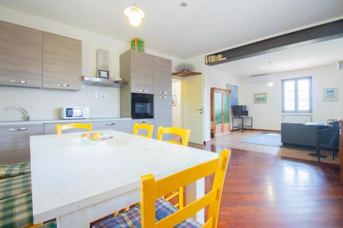 a kitchen and living room with a table and chairs at swimming pool and private garden, Casa in collina in Barcuzzi