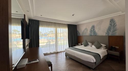 a bedroom with a bed and a desk and a window at Grand Ocean El Sokhna in Ain Sokhna