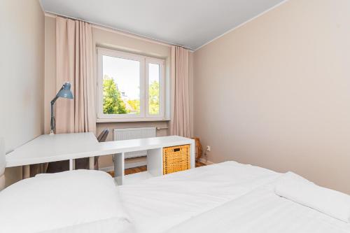 een slaapkamer met twee bedden en een raam bij Frida by Grand Apartments in Gdańsk