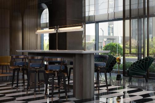 a bar with stools in a room with windows at Hampton by Hilton Guangzhou Baiyun Airport Cultural Tourism City in Guangzhou