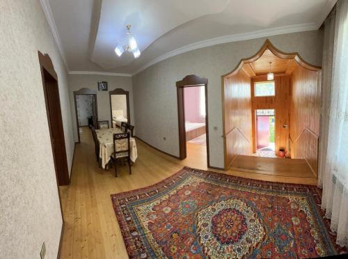 an empty living room with a rug and a table at Yeşil Ev in Gabala