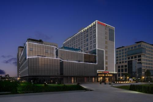 a tall building with a sign on the side of it at Hampton by Hilton Guangzhou Baiyun Airport Cultural Tourism City in Guangzhou