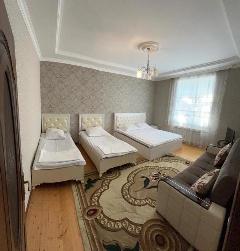 a living room with two beds and a couch at Yeşil Ev in Gabala