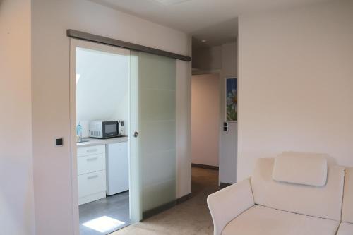 a living room with a chair and a microwave at Hotel an der Therme in Bad Dürkheim