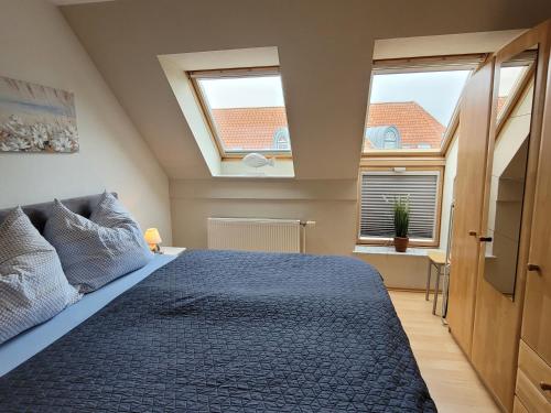 a bedroom with a large bed with two windows at Fewo Büsum in Büsum