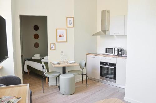 une petite cuisine avec une table et une salle à manger dans l'établissement L'Echappée Bordelaise - Centre Ville - Elégant, à Bordeaux
