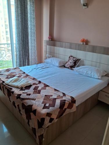 a bed with a quilt on it in a bedroom at Divine Luxury Gateway in Vrindāvan