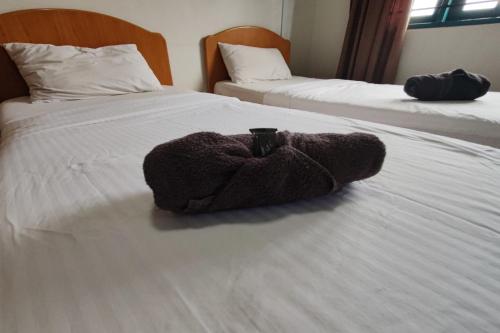a stuffed animal is sitting on a bed at Hotel Check Inn 2 Cameron Highlands in Brinchang