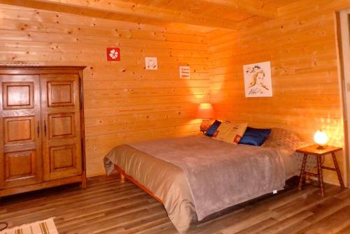 une chambre avec un lit dans une cabane en bois dans l'établissement Le Laou, à Mimet