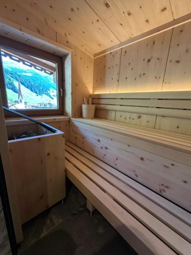 a sauna with a window in a wooden cabin at Hotel Jäger in Tux