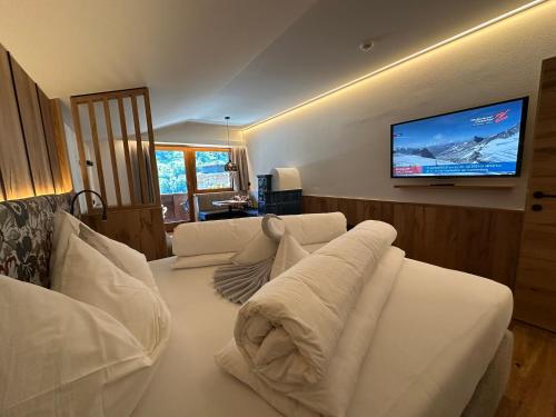 a living room with a white couch and a flat screen tv at Hotel Jäger in Tux