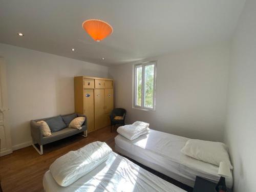 une chambre avec deux lits et un canapé dans l'établissement Maison de charme à 100m de la plage, 2 chambres, cour commune et animaux acceptés - FR-1-413-116, à Capbreton