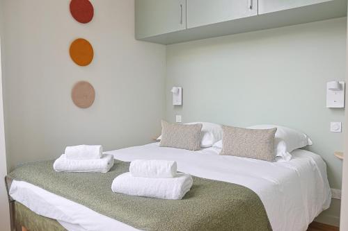 - un grand lit blanc avec des serviettes dans l'établissement L'Echappée Bordelaise - Centre Ville - Elégant, à Bordeaux