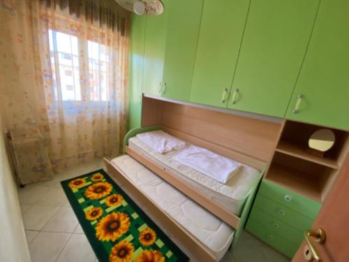 a small bedroom with a bed with a green wall at Apartement Mimosa in Scalea