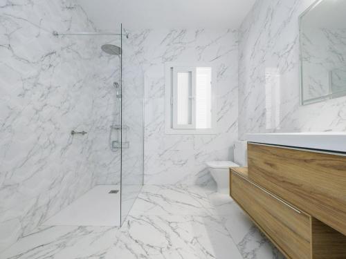 ein weißes Badezimmer mit Dusche und Toilette in der Unterkunft Cubo's Villa La Butibamba in La Cala de Mijas