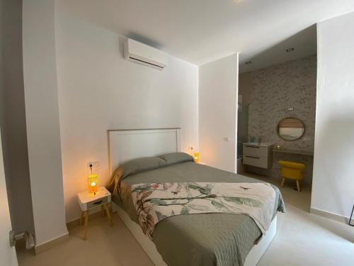 Un dormitorio con una cama y dos lámparas sobre una mesa. en Sol Sherry, en Jerez de la Frontera