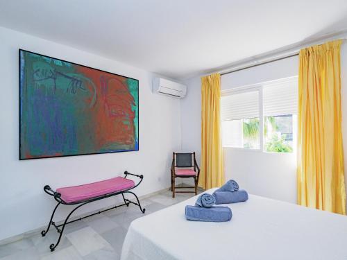 ein Schlafzimmer mit einem Tisch und einem Stuhl und einem Gemälde in der Unterkunft Cubo's Villa La Butibamba in La Cala de Mijas