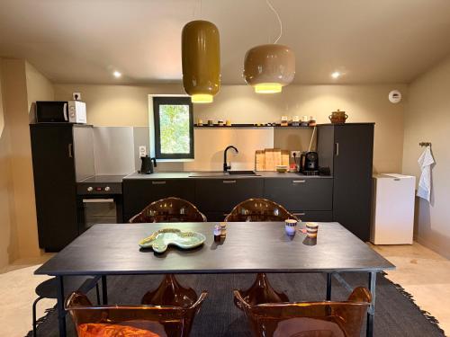 a kitchen with a table and chairs and a kitchen with a sink at La Maison noire de Fontbelle in Angoulême