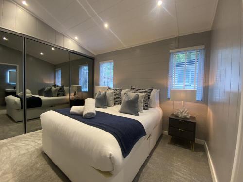 a bedroom with a large white bed and a mirror at V29 - Rivers Retreat in Bethesda