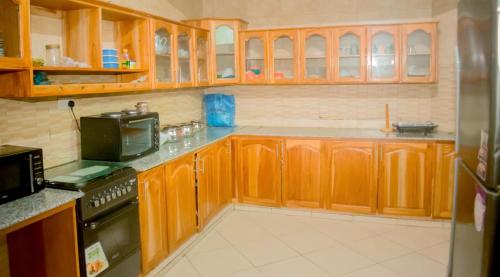 a kitchen with wooden cabinets and a stove at Amani home in Nkunjila