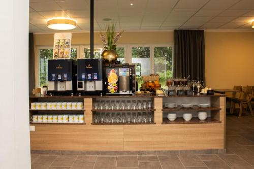 a coffee shop with a counter with drinks on it at OEKOTEL Graz Airport in Kalsdorf bei Graz