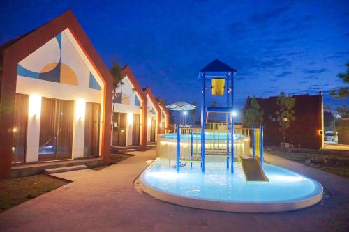 a playground in front of a building at night at Treehita Cabin Jogja in Sleman