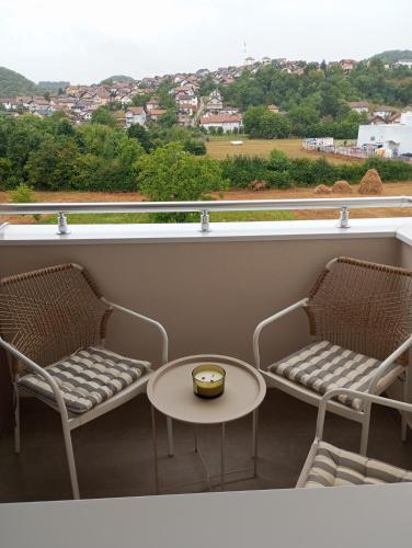 a balcony with two chairs and a table and a window at Apartman Sunset Doboj in Doboj