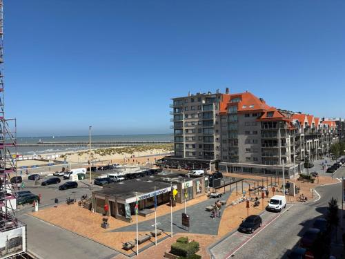 a view of a beach with a building and a parking lot at Hotel Uilenspiegel in Nieuwpoort