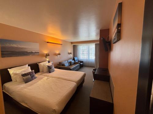 a hotel room with a bed and a couch at Hotel Uilenspiegel in Nieuwpoort