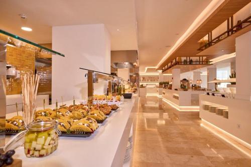 a bakery with a counter filled with lots of bananas at Aparthotel Ponent Mar in Palmanova