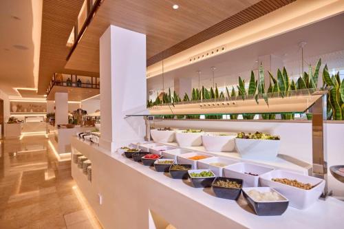 a buffet line with bowls of food and plants at Aparthotel Ponent Mar in Palmanova