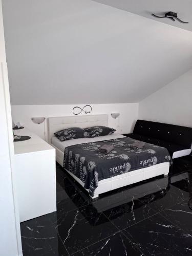 a bedroom with a bed and a black floor at Sunshine apartments in Karlobag